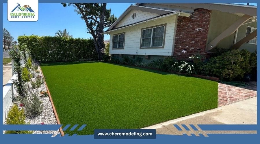 A manicured residential front yard featuring vibrant artificial turf, stone borders, and professional landscaping.
