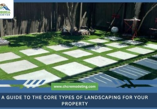 A modern backyard landscape featuring large square concrete pavers set in a grid pattern within a lush green lawn.