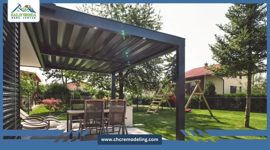 Backyard dining set arranged under a modern dark metal louvered pergola with integrated lighting by California Home Center.