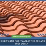 Close-up of overlapping terracotta roof tiles, with text reading, "Discover how long roof warranties are and what they cover."