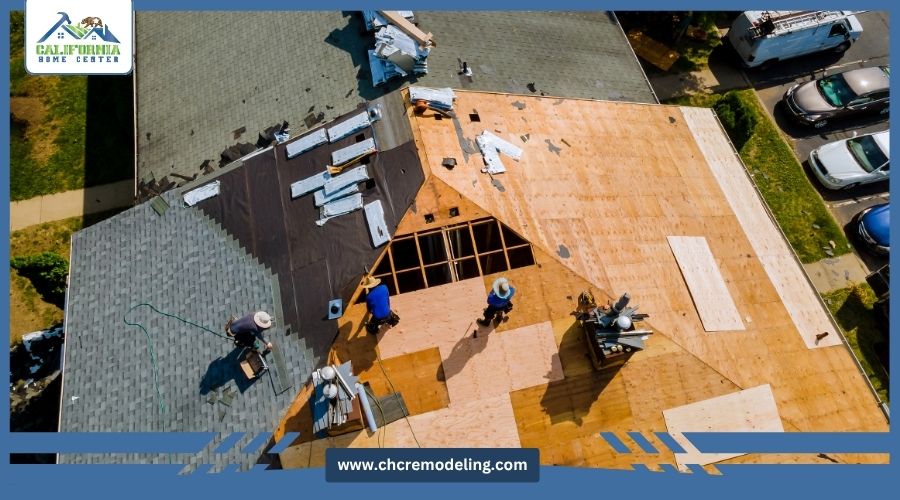 Aerial view of a roofing crew working on a residential roof replacement, showing exposed wood decking and new shingles.